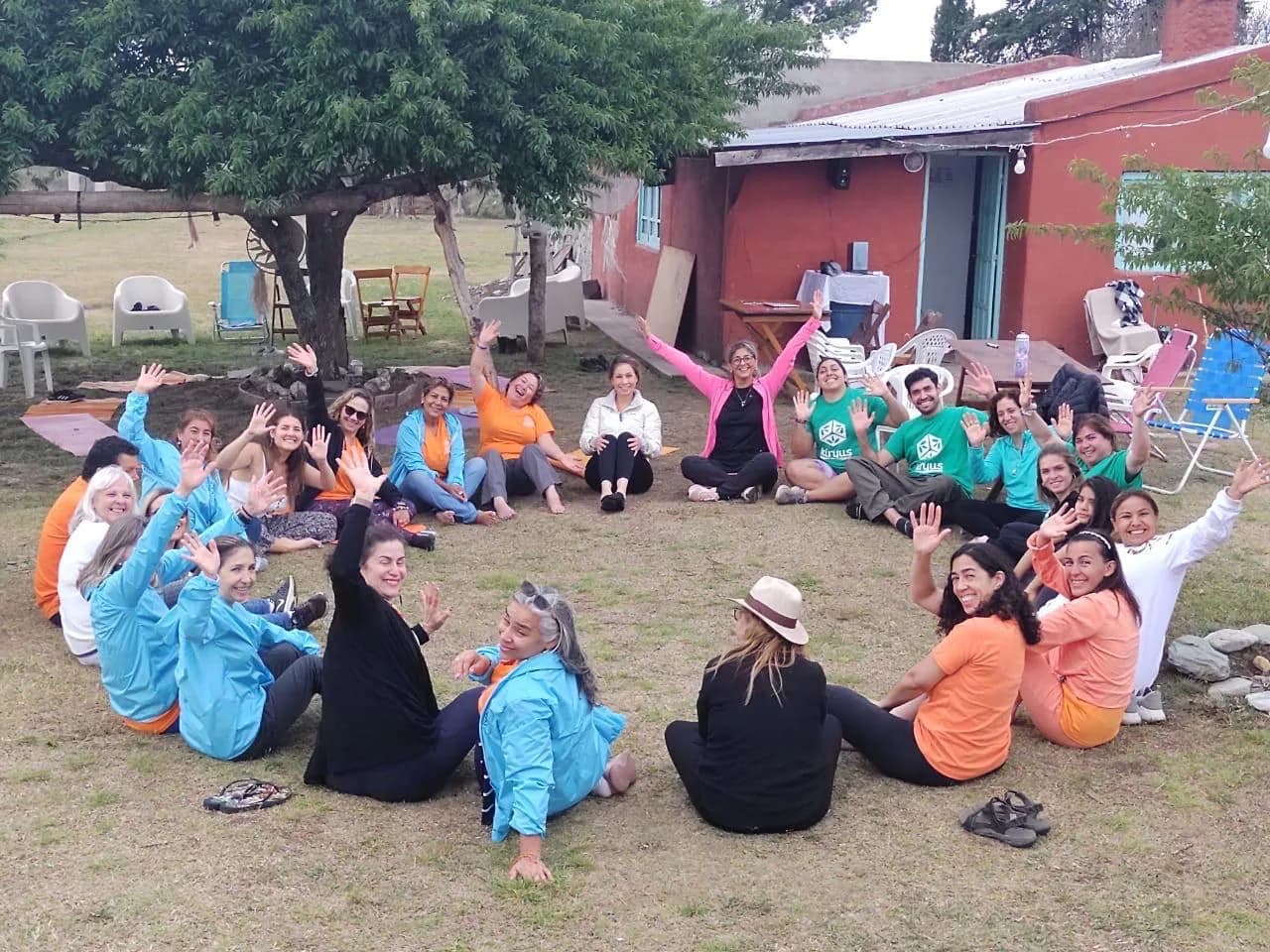 Grupo de personas sentadas en círculo junto a construcciones.